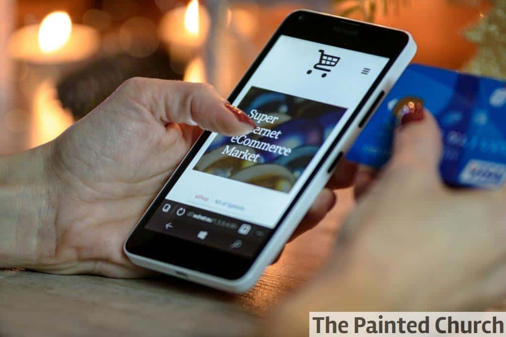 Person Using Black And White Smartphone and Holding Blue Card