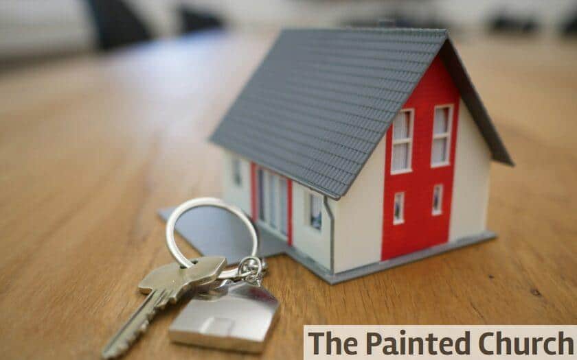 white and red wooden house miniature on brown table
