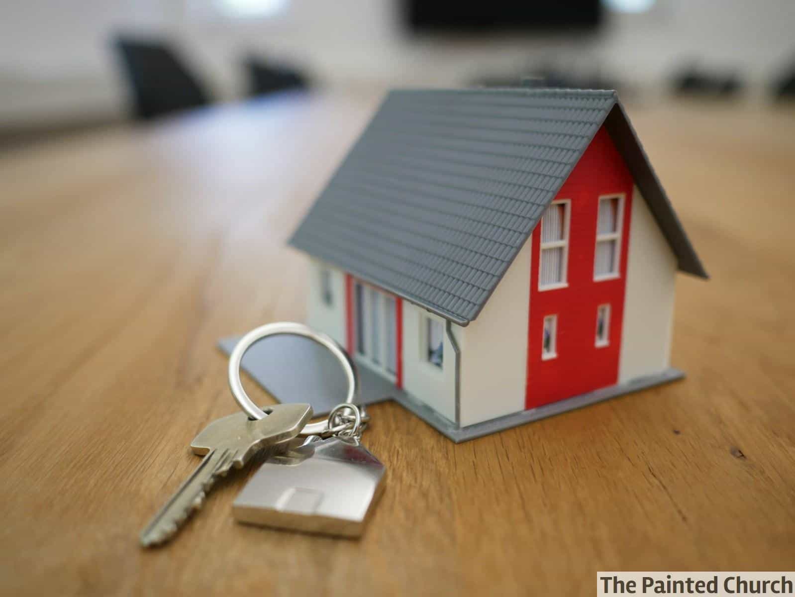 white and red wooden house miniature on brown table