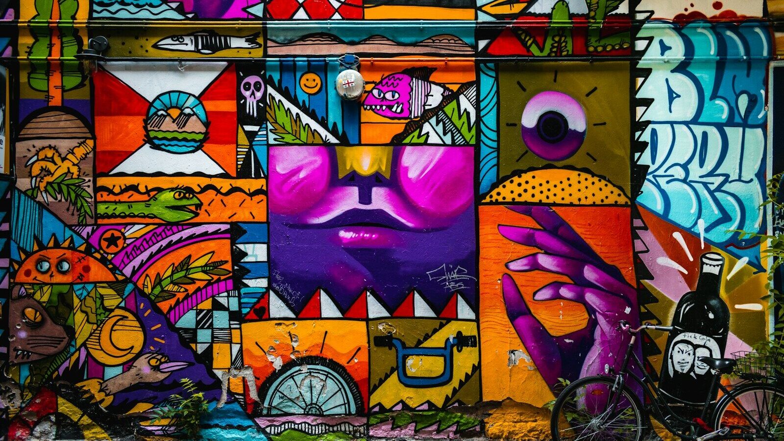 Arte urbano: mural colorido de formas geométricas y personajes en una fachada