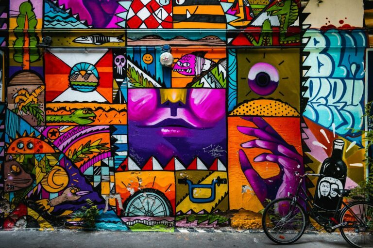 Arte urbano: mural colorido de formas geométricas y personajes en una fachada